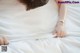 A woman laying in bed with her hands on the sheets.