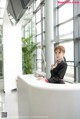 A woman standing at the front desk of a hotel.