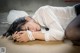 A woman laying on the ground with her head in her hands.