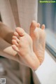 A close up of a person's feet on a window sill.