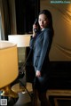 A woman in a business suit talking on a telephone.