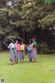 A group of young women standing on top of a lush green field.