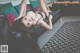 A woman laying on a black couch in a living room.