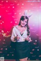 A woman in bunny ears giving a thumbs up.