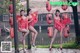 A group of women in red dresses posing for a picture.