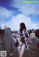 A woman standing on top of a stone wall.