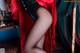 A woman in black stockings and a red cape is posing for a picture.