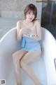 A woman sitting in a bathtub with her legs crossed.