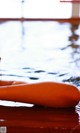 A carrot floating in a pool of water. 