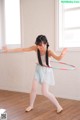 A young girl is playing with a hula hoop.