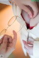 A woman holding a pair of glasses in her hands.