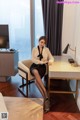 A woman sitting at a desk in a hotel room.