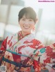 A woman in a kimono smiles at the camera.