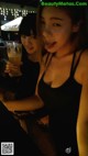 A couple of women standing next to each other holding drinks.