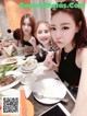 A group of young women sitting at a table with plates of food.