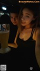 A man and a woman sitting at a table with a glass of beer.