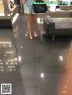 A woman standing in front of a mirror in a store.