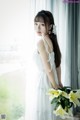 A woman in a white dress holding a bouquet of flowers.