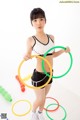 A young woman holding a hula hoop in her hands.