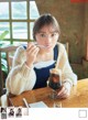 A woman sitting at a table with a glass of coffee.