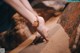 A woman's feet in the sand on a rock.