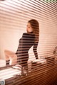 A woman sitting on top of a table next to a window.