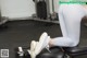 A woman is sitting on a bench in a gym.