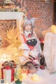 A woman sitting on the floor in front of a Christmas tree.