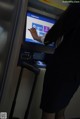 A woman using an atm machine in an airport.