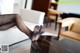 A woman in black pantyhose is sitting on a coffee table.