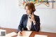 A woman sitting at a table talking on a cell phone.